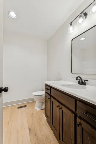 a bathroom with a sink a toilet and a mirror