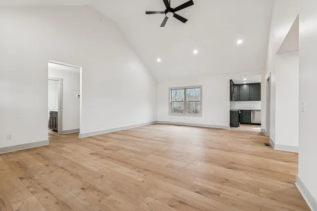 a view of empty room with a fireplace and wooden floor