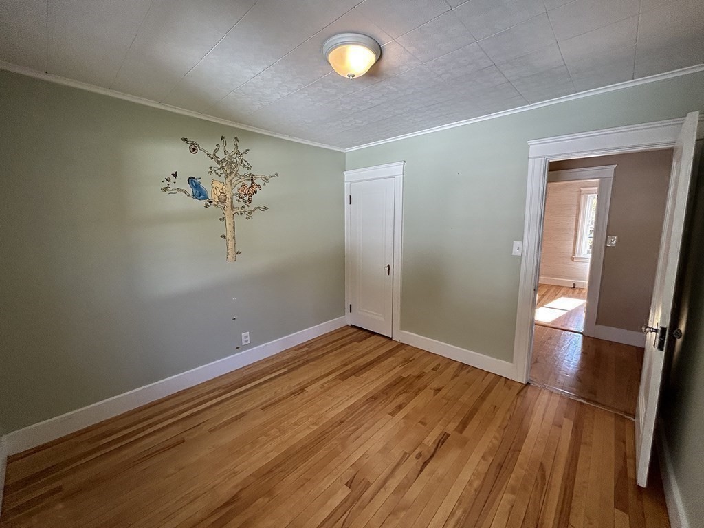 175 June Street Worcester, MA 01602 - Photo 24 of 30 an empty room with wooden floor and mirror