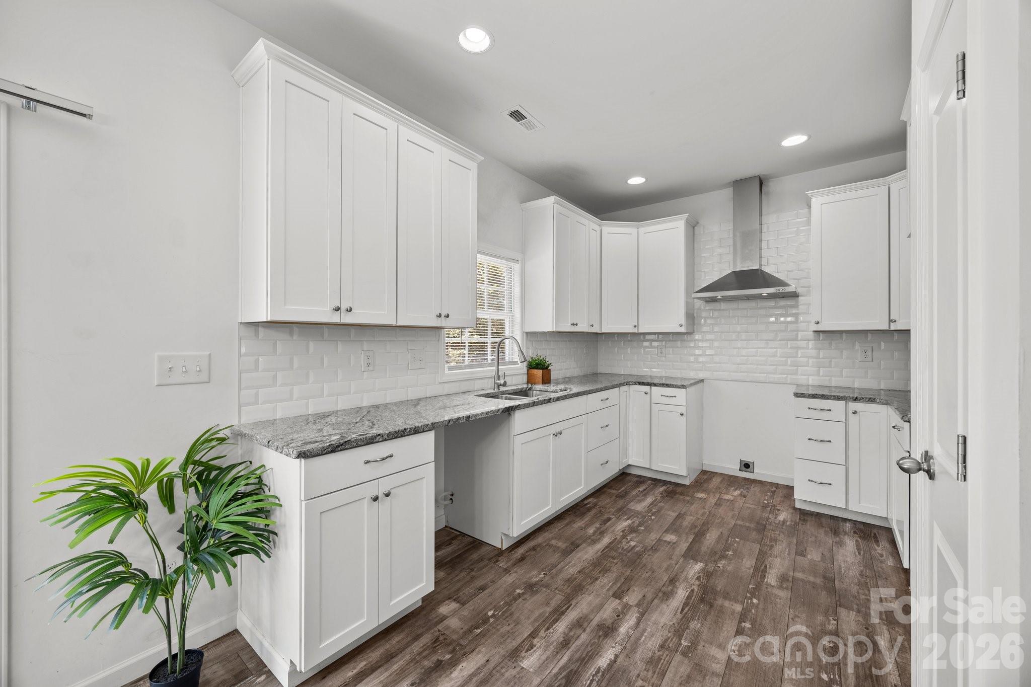 14532 East Rocky River Road Davidson, NC 28036 - Photo 18 of 32 a kitchen with white cabinets and a potted plant