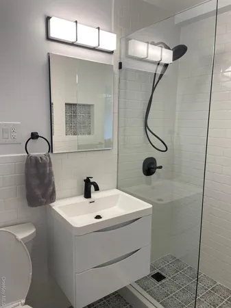 a bathroom with a sink a toilet and shower