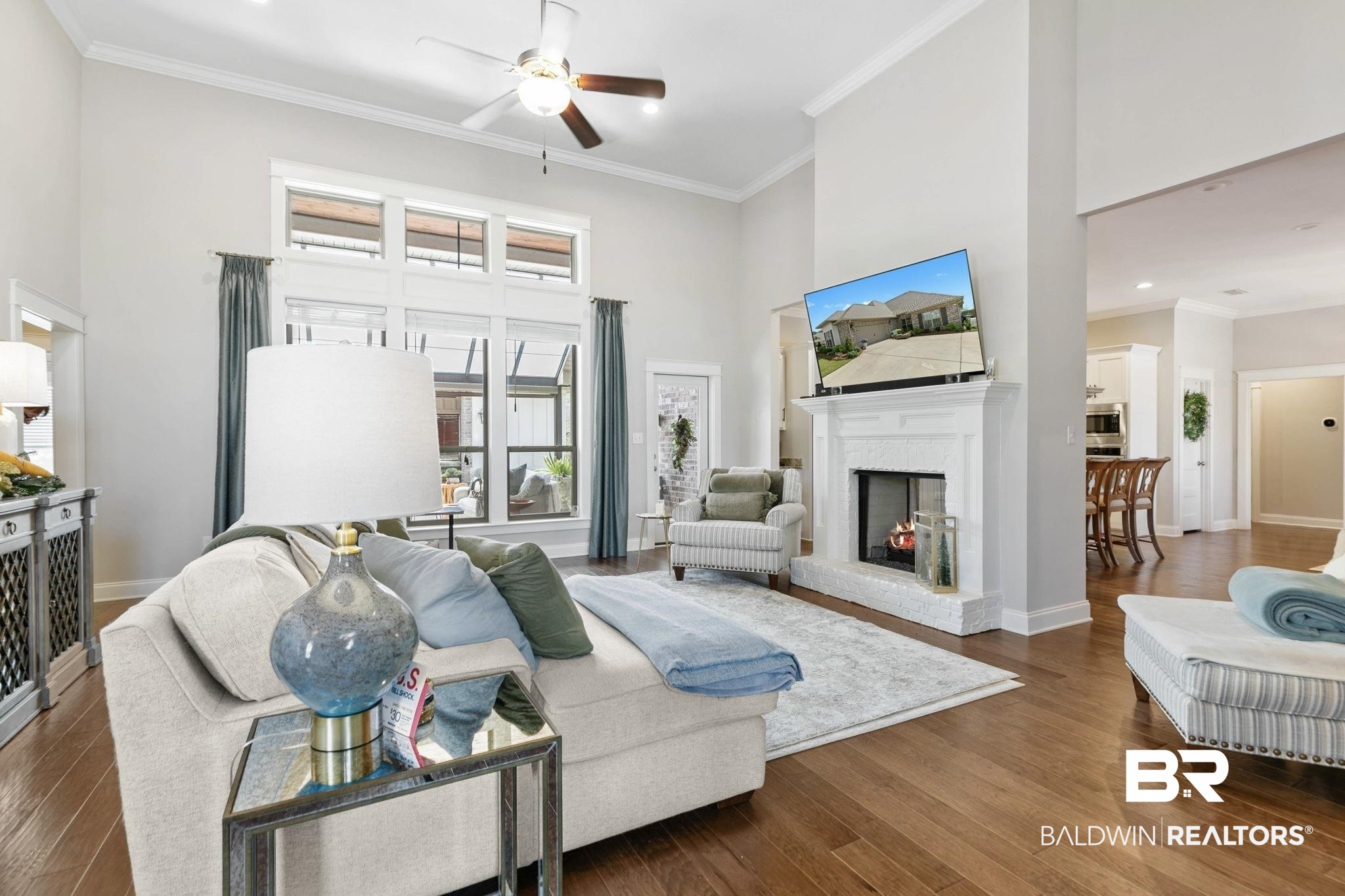 291 Hemlock Drive Fairhope, AL 36532 - Photo 10 of 65 Living room with a high ceiling, crown molding, a ceiling fan, dark wood-type flooring, and a brick fireplace