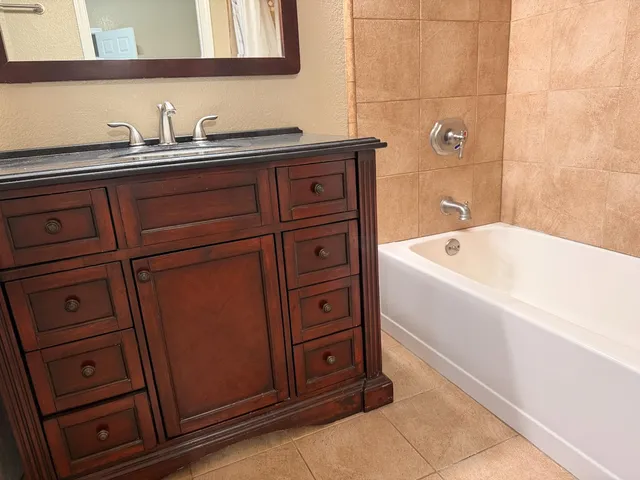 a bathroom with a tub sink and mirror