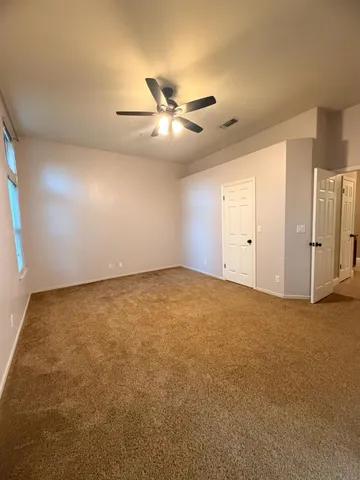 an empty room with closet and windows