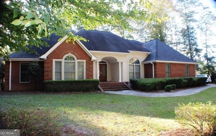 a front view of a house with a garden