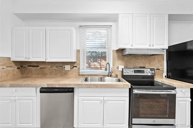 a kitchen with stainless steel appliances granite countertop a sink stove and microwave