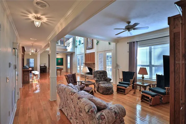 a kitchen with stainless steel appliances granite countertop a refrigerator a sink dishwasher a stove and a dining table with wooden floor