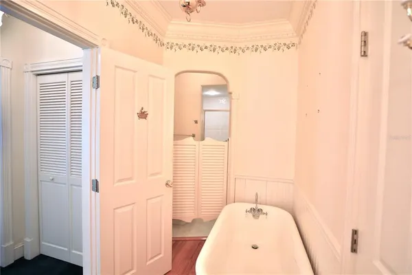 a view of a room with a ceiling fan and hardwood floor