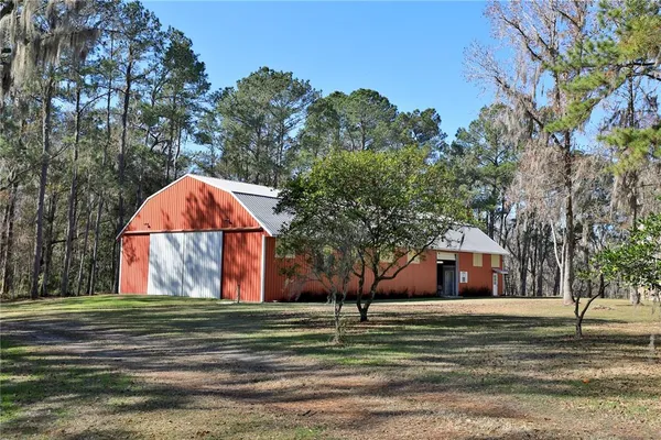 an aerial view of a house with a swimming pool and trees