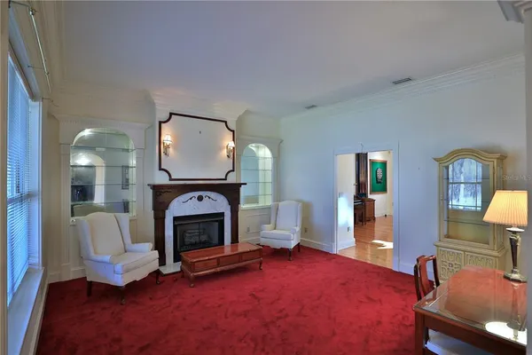 a living room with furniture a ceiling fan and a large window