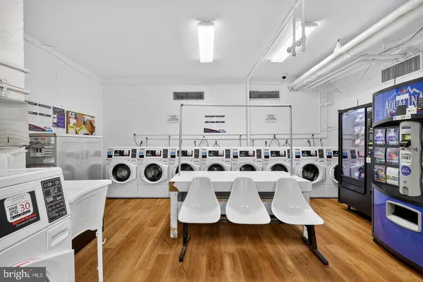 a white kitchen with wooden floor and white walls