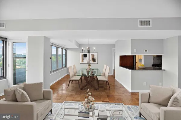 a living room with furniture a flat screen tv and floor to ceiling window