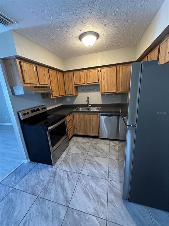 1025 Apollo Beach Boulevard, Unit D Apollo Beach, FL 33572 - Photo 3 of 8 a kitchen with granite countertop a stove a sink and a refrigerator