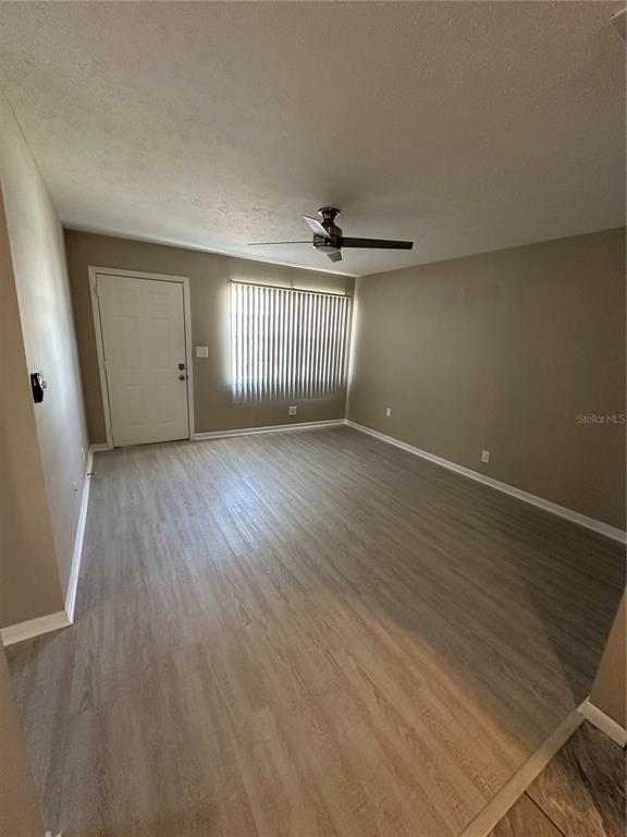 1025 Apollo Beach Boulevard, Unit D Apollo Beach, FL 33572 - Photo 7 of 8 an empty room with wooden floor and windows