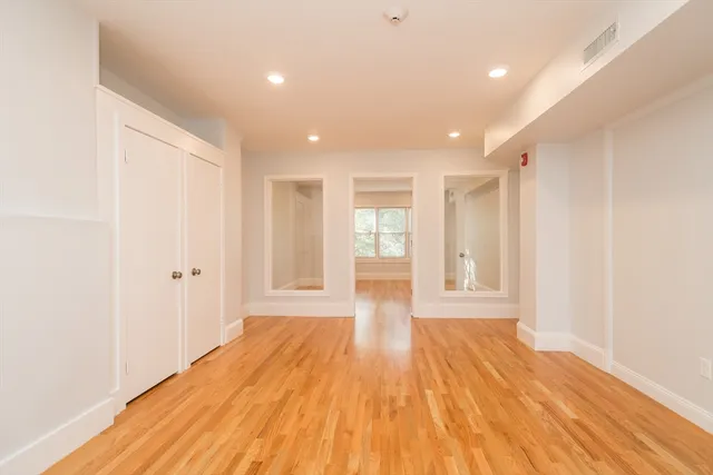 a view of an empty room with wooden floor