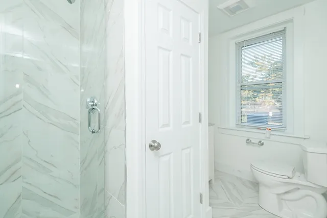 a bathroom with a granite countertop toilet sink and mirror