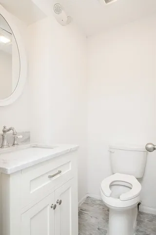 a bathroom with a granite countertop toilet sink and mirror