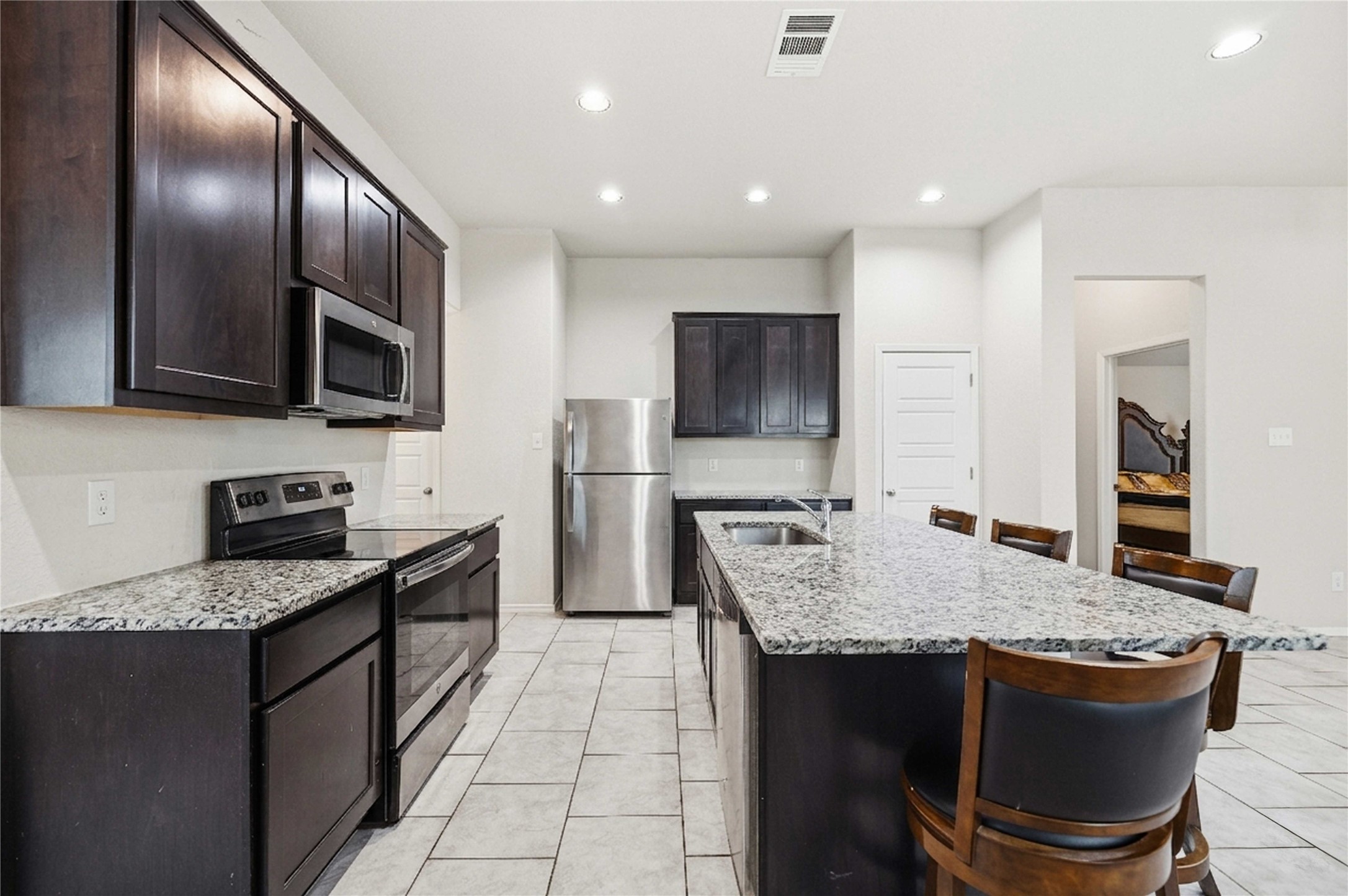 107 Saranac Drive Elgin, TX 78621 - Photo 5 of 17 a kitchen with granite countertop stainless steel appliances a sink stove and refrigerator