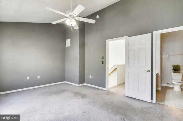an empty room with closet and a ceiling fan