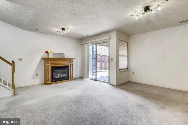 a view of an empty room with a fireplace and a window