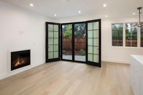 a view of an empty room with a fireplace and a window