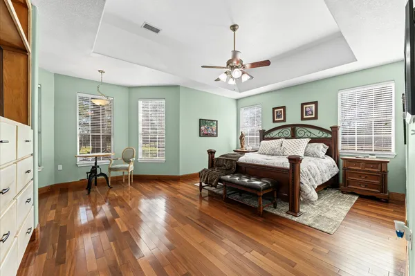 a bedroom with a bed windows and a chandelier