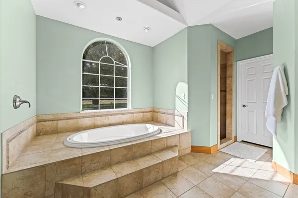 a bathroom with a tub a sink and a window