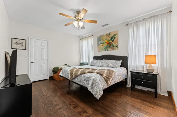 a spacious bedroom with a bed and a flat screen tv