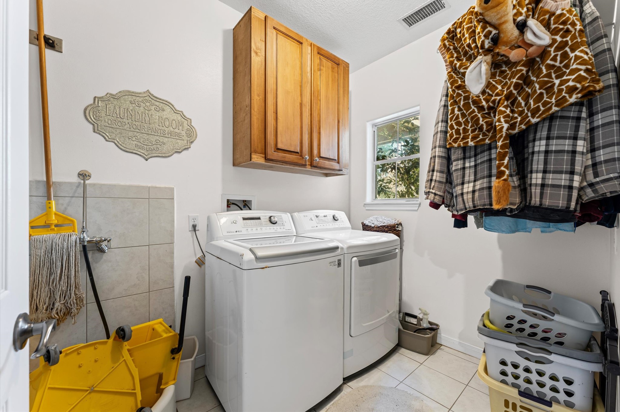 21550-21554 Mueschke Road Tomball, TX 77377 - Photo 19 of 42 Functional laundry room equipped with a washer and dryer, wall-mounted cabinets for storage, and a small window providing natural light. The room includes hanging space for clothes