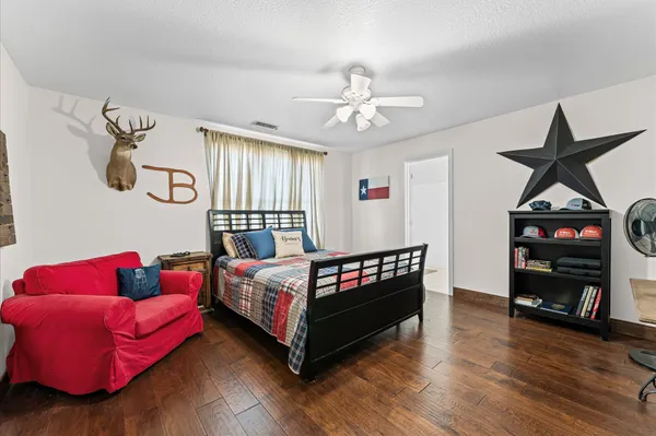 a bedroom with a bed and wooden floor
