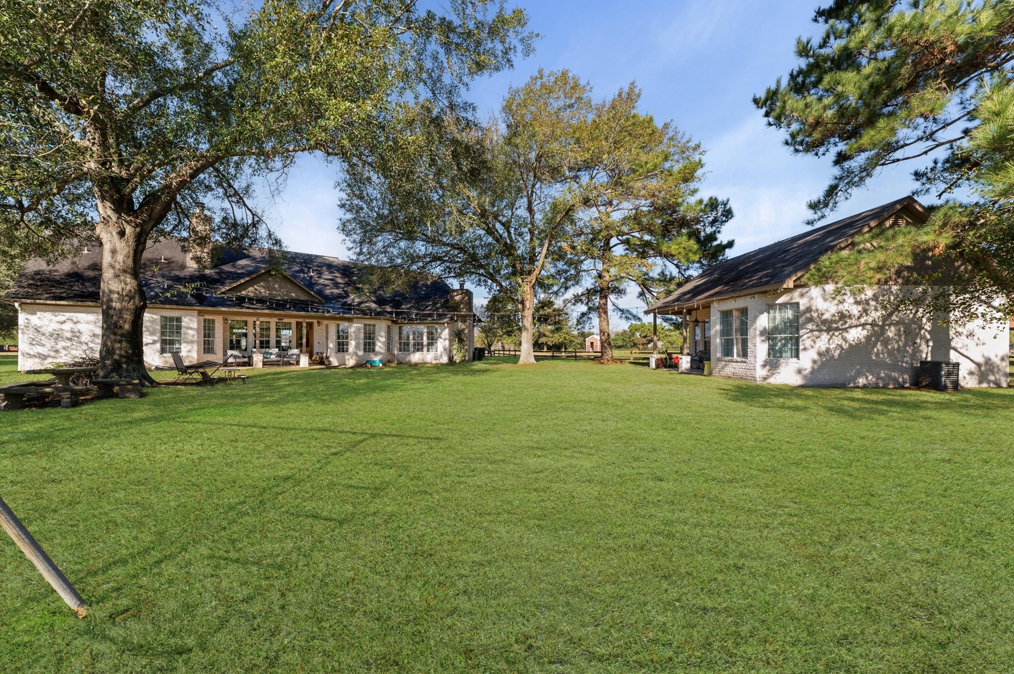 21550-21554 Mueschke Road Tomball, TX 77377 - Photo 25 of 42 The backyard is large and features a guest home with a complete kitchen and full bathroom, a bedroom, and a charming living room with an abundance of natural light