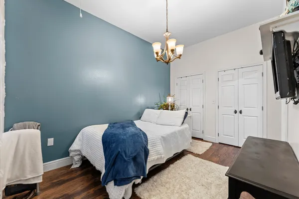 a bedroom with a bed and a chandelier