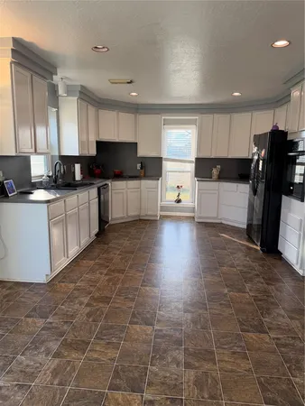 a large kitchen with a stove a sink dishwasher and a refrigerator