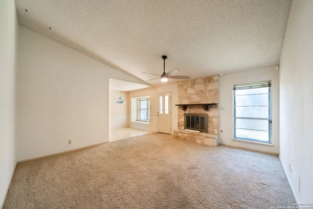an empty room with fireplace and windows