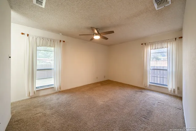 an empty room with closet and windows