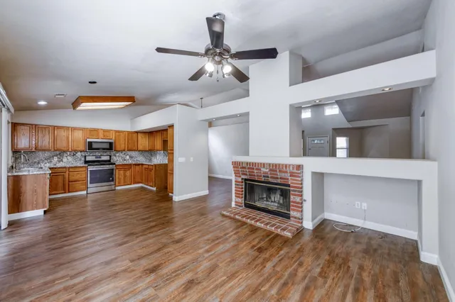 a view of empty room with wooden floor and window