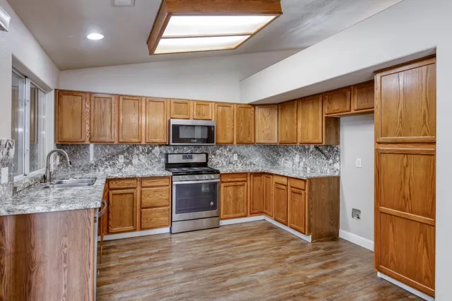 a kitchen with sink a microwave and cabinets