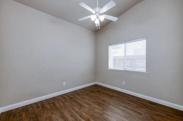 a view of a big room with wooden floor and windows