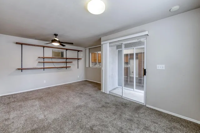 an empty room with windows and ceiling fan
