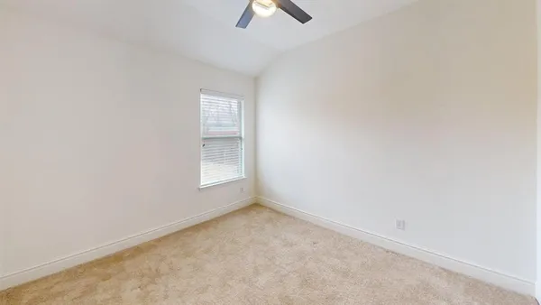 an empty room with chandelier fan
