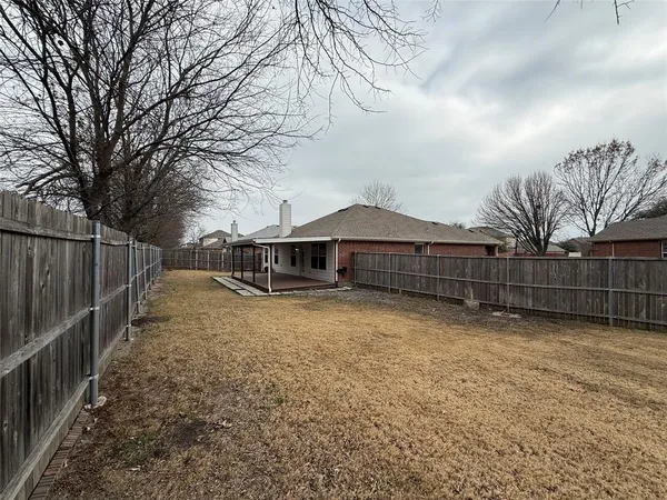 a view of backyard with wooden fence