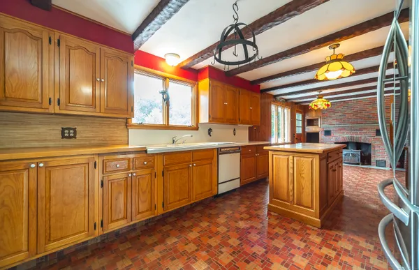 a kitchen with stainless steel appliances granite countertop a sink a stove cabinets counter space and a window