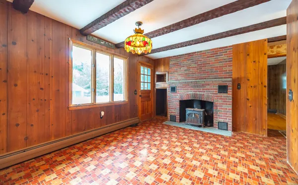 a view of an empty room with a fireplace and a window