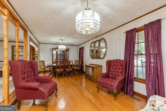 a living room with furniture a dining table and a chandelier