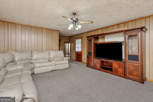 a living room with furniture and a ceiling fan