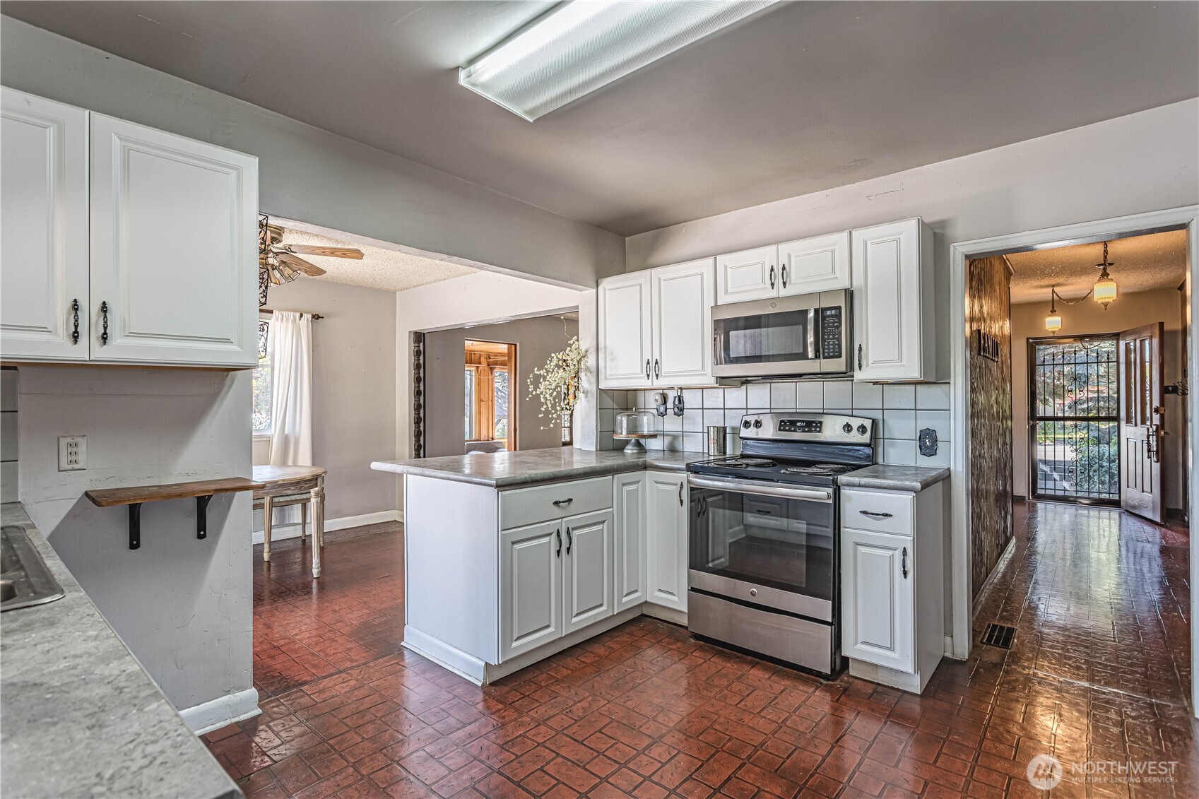 1314 Walnut Street Wenatchee, WA 98801 - Photo 9 of 40 a kitchen with stainless steel appliances granite countertop a stove top oven a sink dishwasher a refrigerator and white cabinets with wooden floor