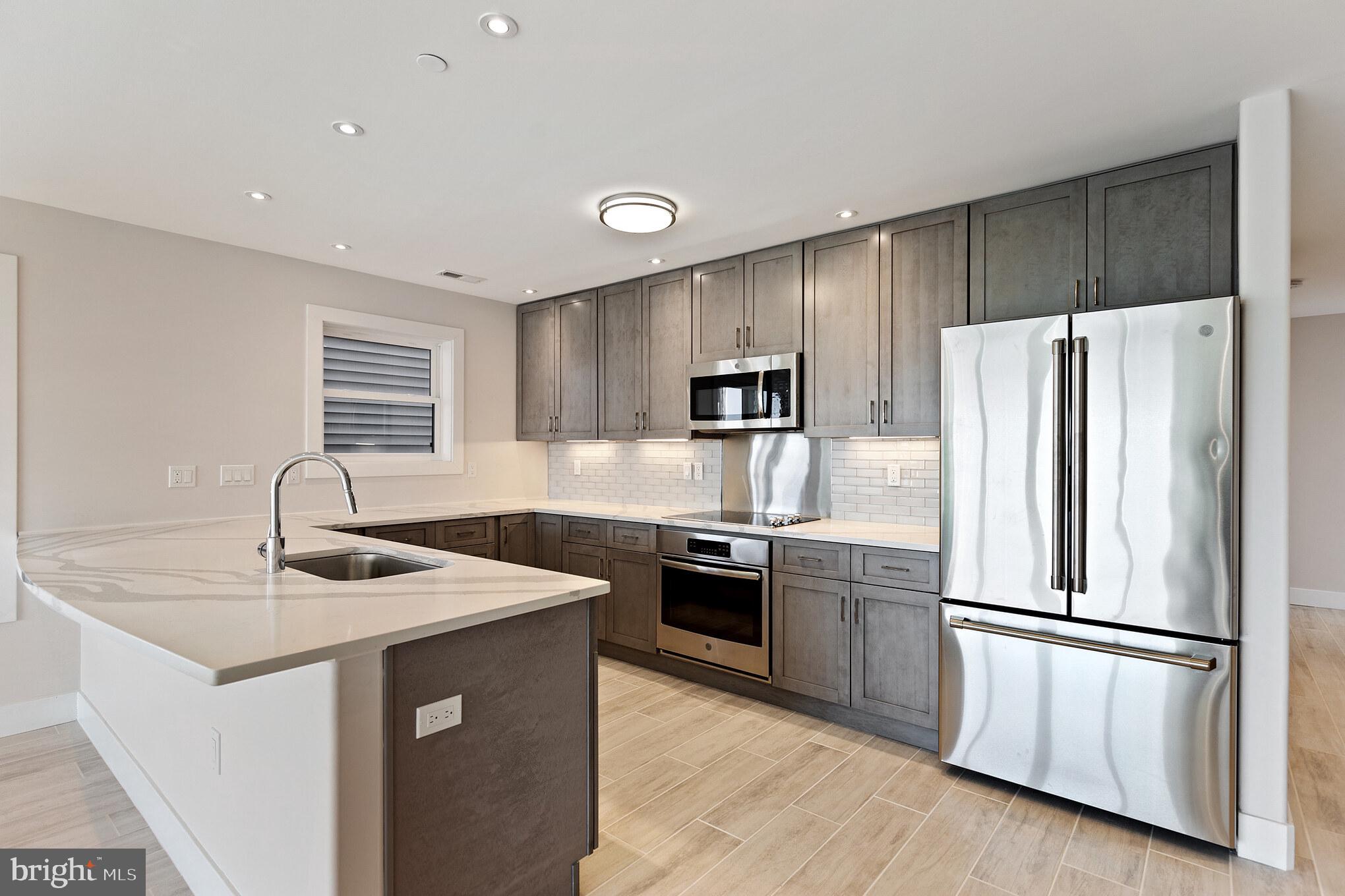 14732 Patuxent Avenue Solomons, MD 20688 - Photo 11 of 31 a kitchen with stainless steel appliances granite countertop a sink stove and refrigerator