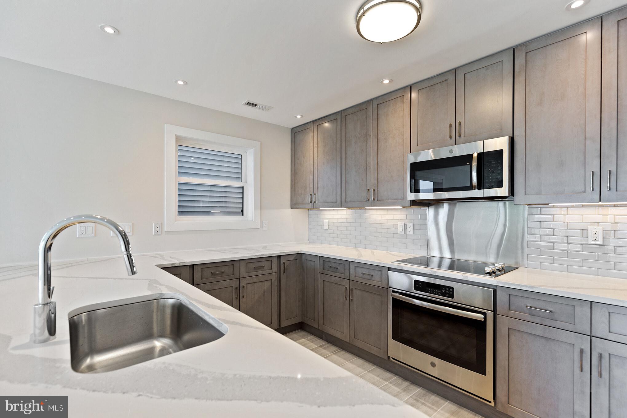 14732 Patuxent Avenue Solomons, MD 20688 - Photo 9 of 31 a kitchen with granite countertop a sink stainless steel appliances and cabinets