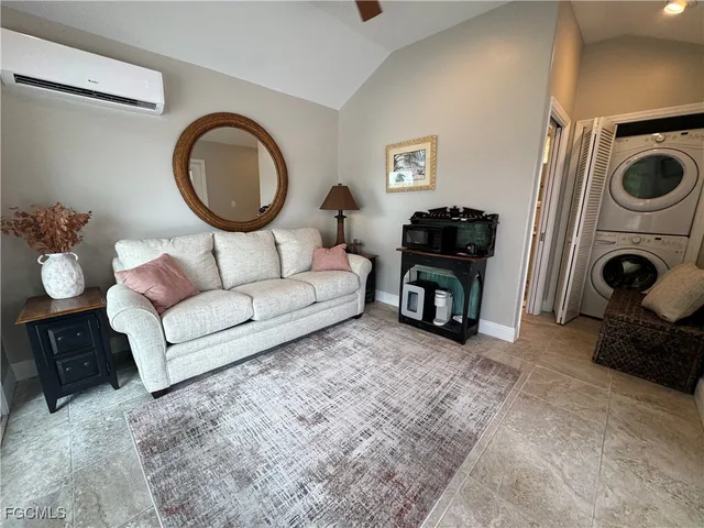 a living room with furniture a flat screen tv and a mirror