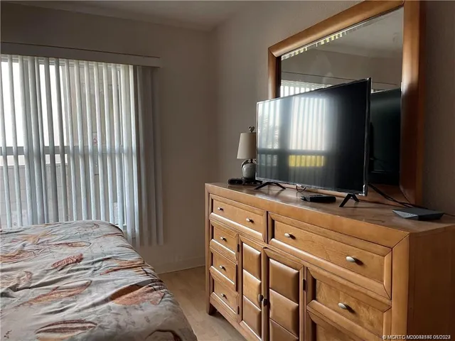 a bedroom with a bed and a flat tv screen on dresser